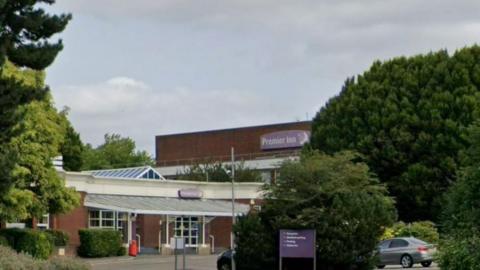 A Premier Inn hotel which is a red brick building with the Premier Inn name in white on a purple background
