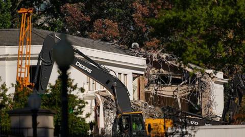 Construction equipment on the east side of the White House, with building debris visible in the foreground
