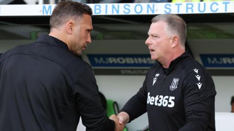 Stoke City boss Mark Robins (right) shakes the hand of Derby County head coach John Eustace