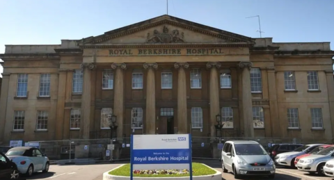 Royal Berkshire Hospital building with blue and white NHS sign out the front in the car park.