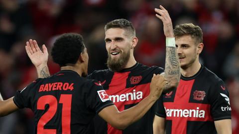 Bayer Leverkusen players celebrate their late equaliser against Stuttgart
