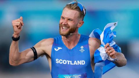 Josh Kerr celebrates winning the mile gold medal