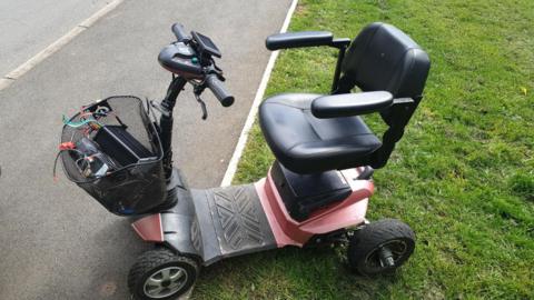 A mobility scooter parked on a grassed kerb