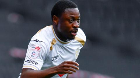 Aaron Nemane in action for MK Dons in their white home shirt