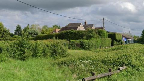 Part of a field and some homes and the primary school in Norton