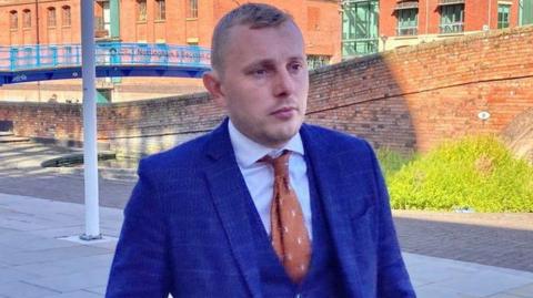 Ashfield District Council deputy leader Thomas Hollis wearing a blue suit outside Nottingham Magistrates' Court 