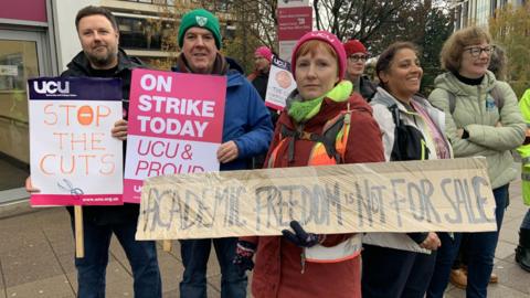 A picket line outside Sheffield Hallam University has a number of people holding placards about strike action