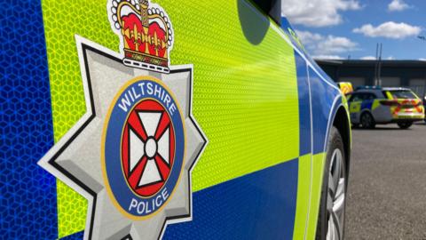 A police car with the Wiltshire Police logo on the car's exterior