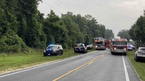 Fire trucks and police vehicles line the street where a bus crashed