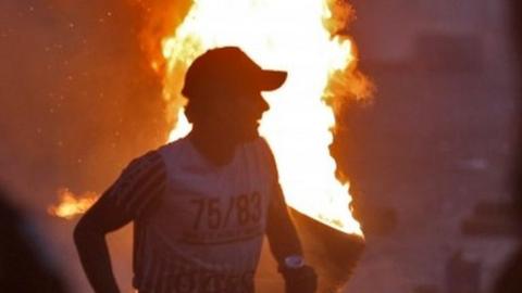 Iraqi protester in front of burning tyres in Baghdad (05/10/19)