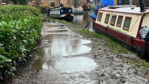 A towpath covered in mud and large puddles.