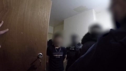 Body worn footage of a man being arrested. He has several police officers around him and all faces are blurred