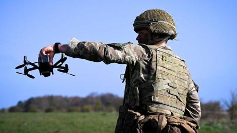 A British soldier holds a drone