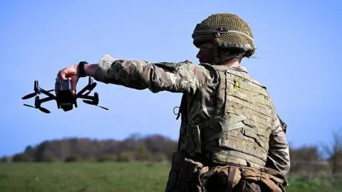A British soldier holds a drone