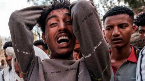 A man reacts as people gather around the body of a young man that witnesses say was shot by security forces after breaking curfew, capital of Tigray on February 27, 2021.