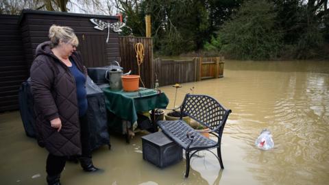 Islip resident Doreen Cole in her flooded garden after the River Cherwell burst its banks earlier