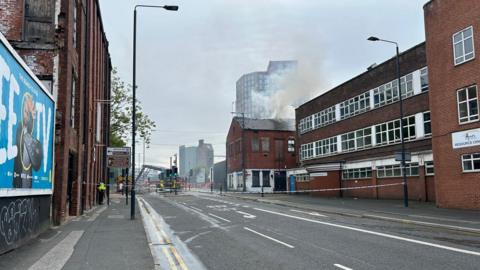 Smoke pours from the top of a disused building in Leeds