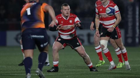 Will Crane (centre) holds his two arms out in front of him and looks at a ball that is coming towards him while playing for Gloucester against Edinburgh