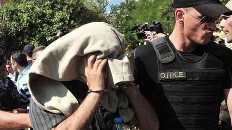 A Greek police officer escorts a Turkish officer who fled to Greece by helicopter after last week's failed coup, as he leaves the courthouse of Alexandroupoli, near the Greek-Turkish border, on July 21, 2016.