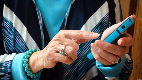 An older woman holding a phone