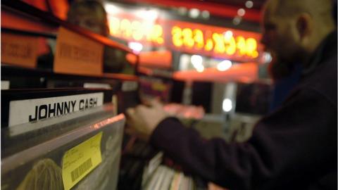 Customers browse through vinyl record albums at Reckless Records on Berwick Street