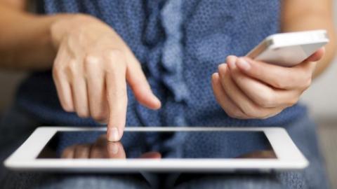 A woman with a tablet and a smart phone