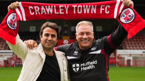 New Crawley Town owner Raphael Khalili and manager Scott Lindsey hold a Crawley Town scarf above their heads