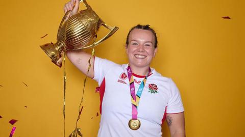 Lark Atkin-Davies holding the Rugby World Cup trophy