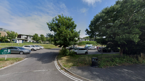 A car park with trees around it. 