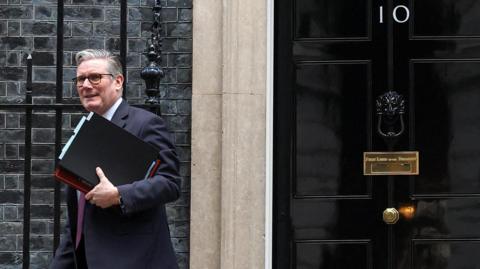 Sir Keir Starmer walking away from the door at to 10 Downing Street with files under his arm