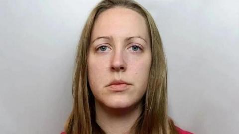 Custody image of Lucy Letby, who has long blonde hair and is wearing a red top.
