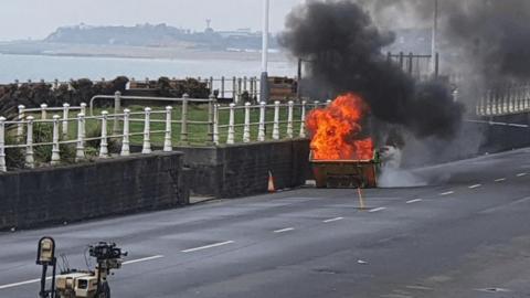 A rubbish bin on fire due to police carrying out a controlled burn on chemicals.