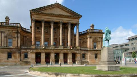 The Grecian sandstone exterior of Paisley Town Hall, which has a number of columns over its entrance. 