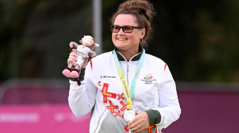 Lucy Beere shows her silver medal in 2022