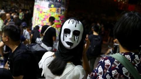 A Hong Kong protester wearing a mask showing a white eyeless face weeping black tears after the local government announced a ban on all face masks