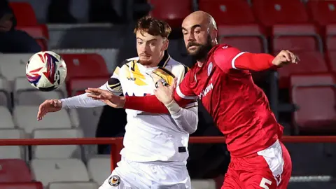 Michael Spellman of Newport County is challenged by Farrend Rawson of Accrington Stanley