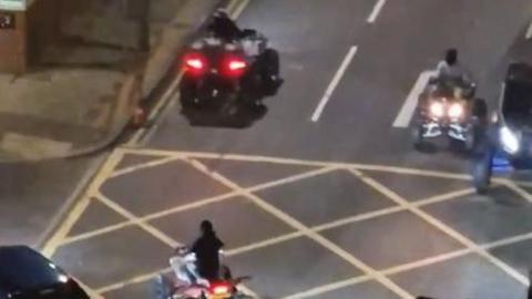 Quad bikers in a city centre after dark