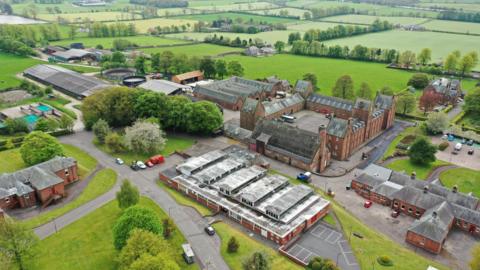 An aerial view of the Crichton Estate in Dumfries with the more modern laundry building in the foreground surrounded by grass and other roads