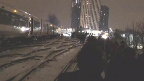 People walking on the tracks near Lewisham