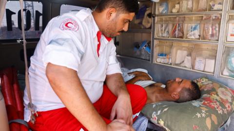 A medic speaks to an injured Palestinian inside an ambulance at Gaza's Rafah border crossing with Egypt (1 November 2023)