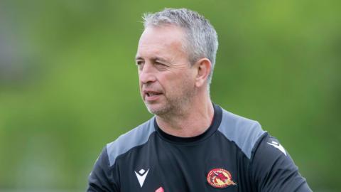 Steve McNamara wearing a Catalans Dragons sweatshirt