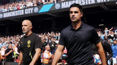Manchester City manager Enzo Maresca (left) and his Arsenal counterpart Mikel Arteta take to the pitch ahead of the 2026 FA Community Shield.