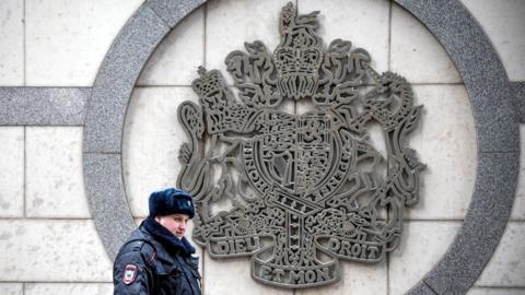 A police officer patrols outside the British embassy building in Moscow