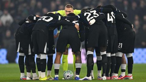 Chelsea gather in a huddle on the pitch at Villa Park
