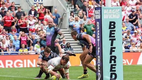 Jai Whitbread of Hull KR touches down under pressure from a Hull FC player