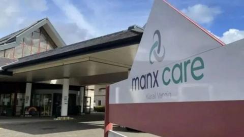 A picture of a Manx Care sign infront of a building
