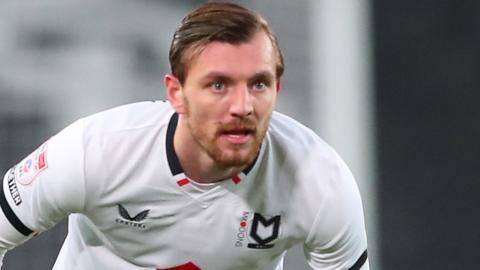 Alex Gilbey of MK Dons was among 12 players booked in the game against AFC Wimbledon