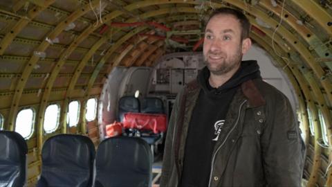 Dave Billings stood in the old plane fuselage