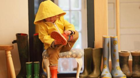 Child putting on welly boots 