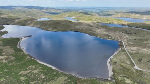 Delwedd drôn o Byllau Teifi gyda Llyn Egnant yn y blaendir.